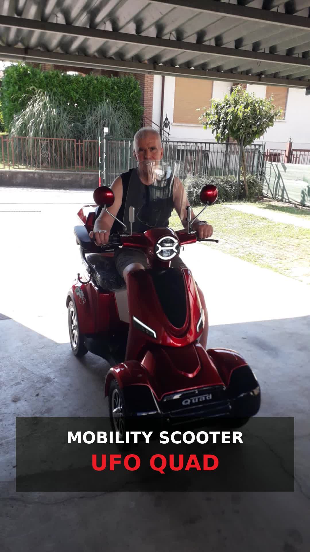 Un cliente a bordo di un mobility scooter UFO QUAD rosso durante una consegna